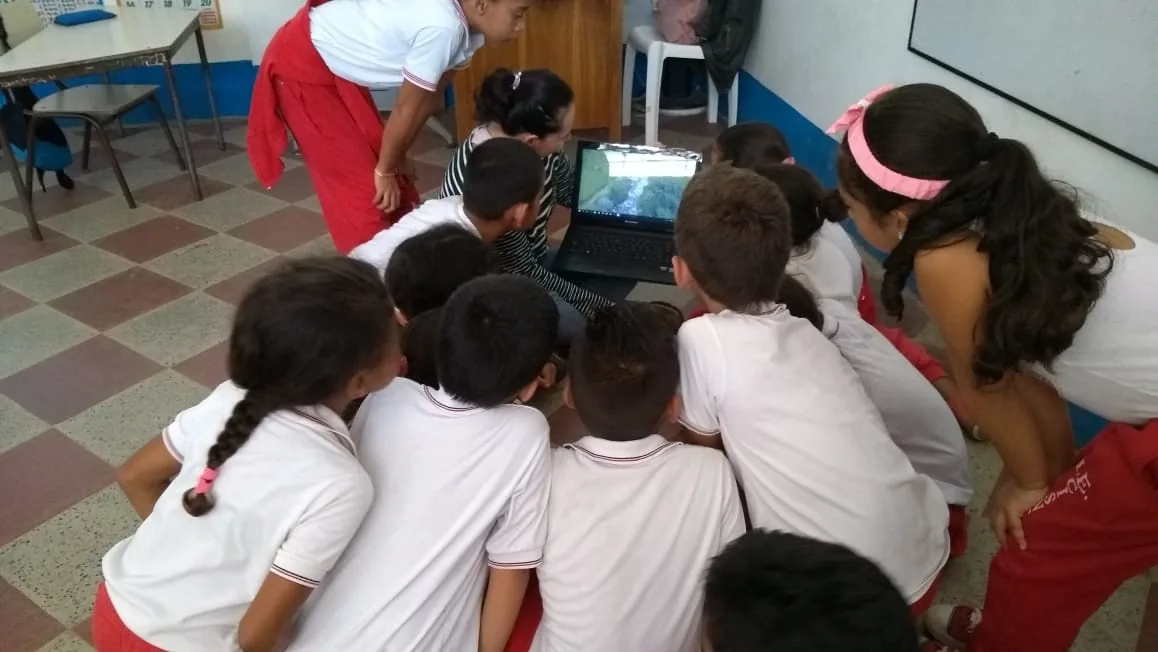Sesión de educación ambiental en un salón con miembros de la comunidad.
